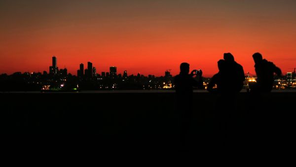 Syrian refugees take a pictures as they gather on the shores of the town of Dbayeh north of Beirut as the sun sets over the Lebanese capital on February 5, 2017. - Sputnik International