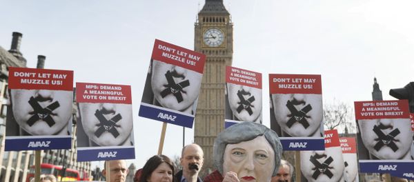 Demonstrators, one dressed in a Theresa May puppet head pose near parliament in London Demonstrators, one dressed in a Theresa May puppet head pose near parliament in London - Sputnik International