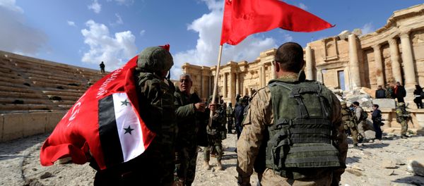 Syrian army soldiers carry flags in the amphitheater of the historic city of Palmyra, Syria March 4, 2017. - Sputnik International