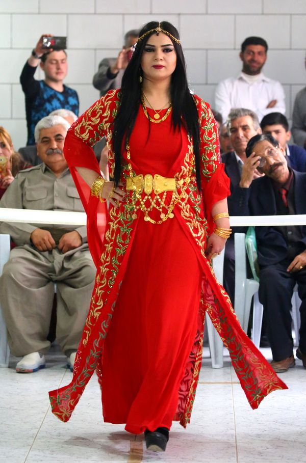 A Syrian-Kurdish model hits the catwalk in a bright red full-length gown, with a red overcoat heavily embroidered in gold. A Syrian-Kurdish model hits the catwalk in a bright red full-length gown, with a red overcoat heavily embroidered in gold. - Sputnik International
