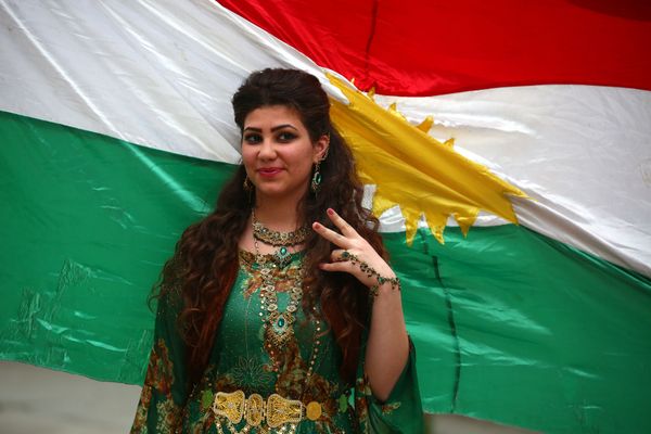 A Syrian-Kurdish model poses in front of Kurdish flag. A Syrian-Kurdish model poses in front of Kurdish flag. - Sputnik International