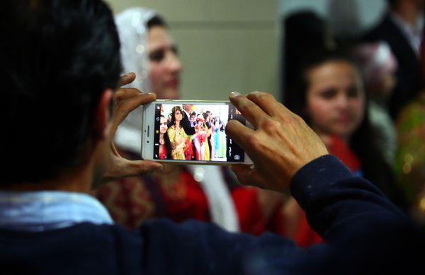 A man takes a photo on his phone of Syrian-Kurdish women modelling traditional Kurdish attire during a fashion show in the northeastern Syrian city of Qamishli on March 10, 2017, which coincides with the Day of Kurdish Clothing. A man takes a photo on his phone of Syrian-Kurdish women modelling traditional Kurdish attire during a fashion show in the northeastern Syrian city of Qamishli on March 10, 2017, which coincides with the Day of Kurdish Clothing. - Sputnik International