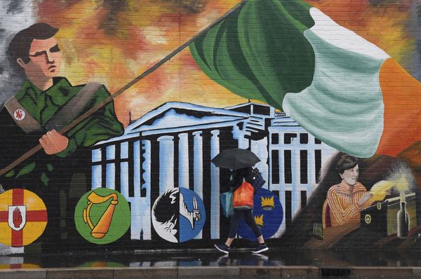 A woman walks past a political mural in the Falls Road area of west Belfast, Northern Ireland, February 28, 2017.  - Sputnik International