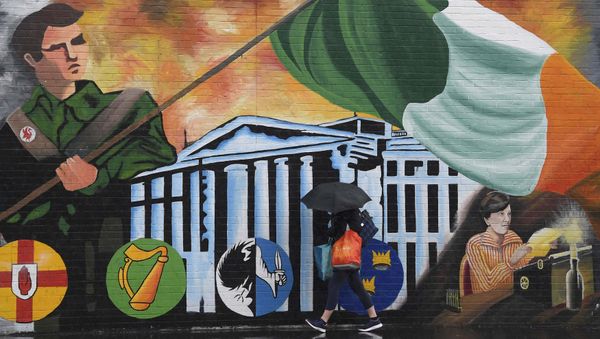 A woman walks past a political mural in the Falls Road area of west Belfast, Northern Ireland, February 28, 2017. - Sputnik International