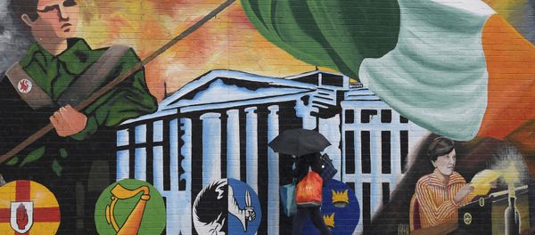 A woman walks past a political mural in the Falls Road area of west Belfast, Northern Ireland, February 28, 2017. A woman walks past a political mural in the Falls Road area of west Belfast, Northern Ireland, February 28, 2017. - Sputnik International