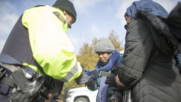 An RCMP officer checks the documents of two women from Sudan after they illegally crossed the Canada-US border. (File) - Sputnik International