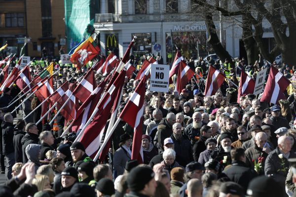 People hold flags and placards, as they participate in the annual procession commemorating the Latvian Waffen-SS (Schutzstaffel) unit, also known as the Legionnaires, in Riga, Latvia March 16, 2017 People hold flags and placards, as they participate in the annual procession commemorating the Latvian Waffen-SS (Schutzstaffel) unit, also known as the Legionnaires, in Riga, Latvia March 16, 2017 - Sputnik International