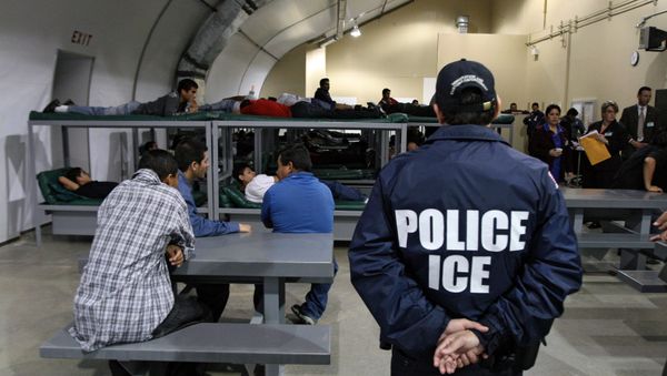 An Immigration and Customs Enforcement (ICE) officer guards a group of 116 Salvadorean immigrants that wait to be deported,at Willacy Detention facility in Raymondville, Texas on December 18, 2008 - Sputnik International