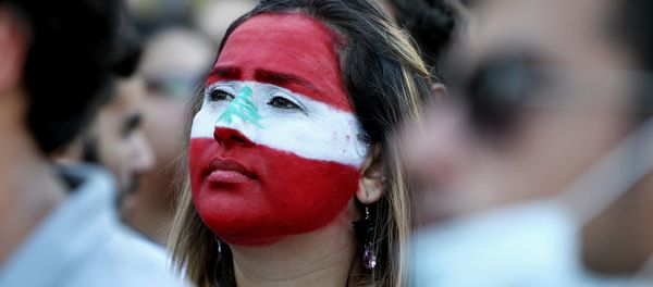 A Lebanese woman, with her face painted in the colours of Lebanon's national flag, takes part in a demonstration in downtown Beirut on August 8, 2015 - Sputnik International