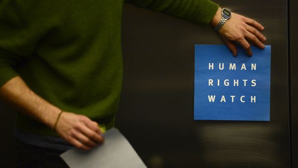 A man puts a logo of US-based rights group Human Rights Watch on the wall as he prepares the room before their press conference to release their annual World report on January 21, 2014 in Berlin A man puts a logo of US-based rights group Human Rights Watch on the wall as he prepares the room before their press conference to release their annual World report on January 21, 2014 in Berlin - Sputnik International
