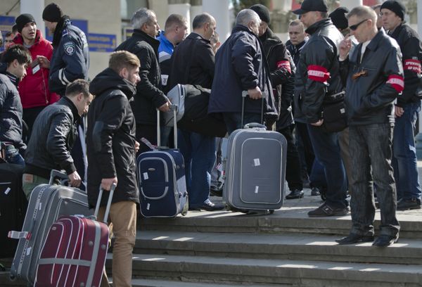 Members of the Crimean self defense forces check passengers at the main railway station in Simferopol, Ukraine, Friday, March 14, 2014 - Sputnik International