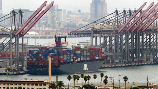 An American President Lines ship loaded with containers is moored next to idle cranes at the Port of Long Beach (File) - Sputnik International