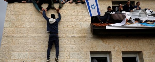 A pro-settlement activist climbs onto a rooftop of a house to resist evacuation of some houses in the settlement of Ofra in the occupied West Bank, during an operation by Israeli forces to evict the houses, February 28, 2017. - Sputnik International