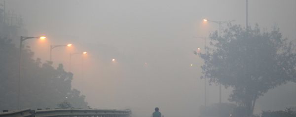 A man rides a scooter on a road enveloped by smoke and smog, on the morning following Diwali festival in New Delhi, India, Monday, Oct. 31, 2016. - Sputnik International