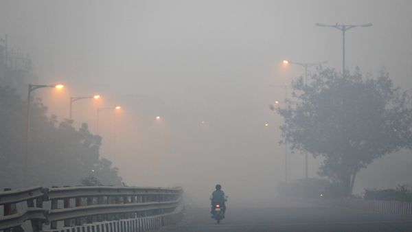 A man rides a scooter on a road enveloped by smoke and smog, on the morning following Diwali festival in New Delhi, India, Monday, Oct. 31, 2016. - Sputnik International