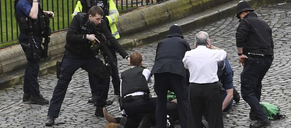 A policeman points a gun at a man on the floor as emergency services attend the scene outside the Palace of Westminster, London, Wednesday, March 22, 2017. - Sputnik International