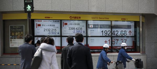 Pedestrians cross a street next to an electric quotation board flashing the Nikkei key index of the Tokyo Stock Exchange (TSE) in Tokyo on March 24, 2017 - Sputnik International
