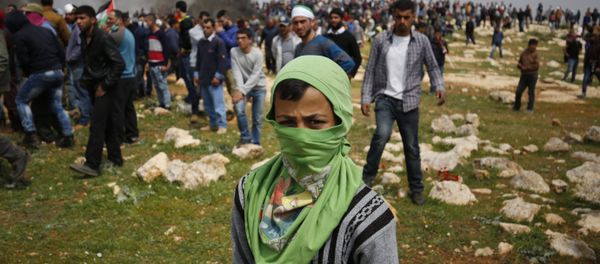 A young Palestinian protestor poses for a photo during clashes with Israeli security forces following a demonstration against Jewish settlements in village of al-Mughayyir, near the West Bank city of Ramallah, on March 24, 2017 - Sputnik International