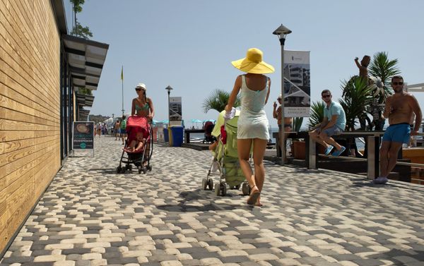 Mothers with baby-strollers walk on the waterfront running along Massandra Beach, Yalta Mothers with baby-strollers walk on the waterfront running along Massandra Beach, Yalta - Sputnik International