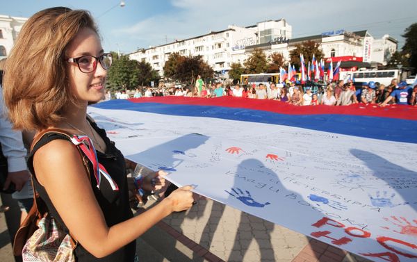 Simferopol residents during the Russian Flag Day celebrations in Crimea. A 162 sq m Russian flag has been spread on the central square in the Crimean capital Simferopol residents during the Russian Flag Day celebrations in Crimea. A 162 sq m Russian flag has been spread on the central square in the Crimean capital - Sputnik International