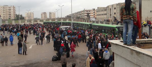 Opposition fighters and their families gather as they prepare to board a bus, ahead of their evacuation from the rebel-held Waer neighbourhood in the central city of Homs on March 18, 2017 - Sputnik International