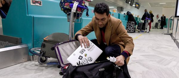 A Libyan traveller packs his laptop in his suitcase before boarding his flight for London at Tunis-Carthage International Airport on March 25, 2017 - Sputnik International