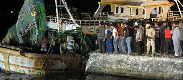 This file photo taken on September 28, 2016 shows people gathering on the quay as a wreck of a migrant boat raised by the Egyptian navy and maritime rescuers arrives in the Egyptian port city of Rosetta. An Egyptian court on March 26, 2017 sentenced 56 people to prison terms of between seven and 10 years over the deaths at sea of at least 202 migrants in September, judicial officials said This file photo taken on September 28, 2016 shows people gathering on the quay as a wreck of a migrant boat raised by the Egyptian navy and maritime rescuers arrives in the Egyptian port city of Rosetta. An Egyptian court on March 26, 2017 sentenced 56 people to prison terms of between seven and 10 years over the deaths at sea of at least 202 migrants in September, judicial officials said - Sputnik International