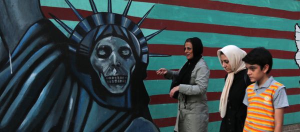 An Iranian family walks past anti-US graffiti on the wall of the former US embassy in Tehran on July 14, 2015 An Iranian family walks past anti-US graffiti on the wall of the former US embassy in Tehran on July 14, 2015 - Sputnik International