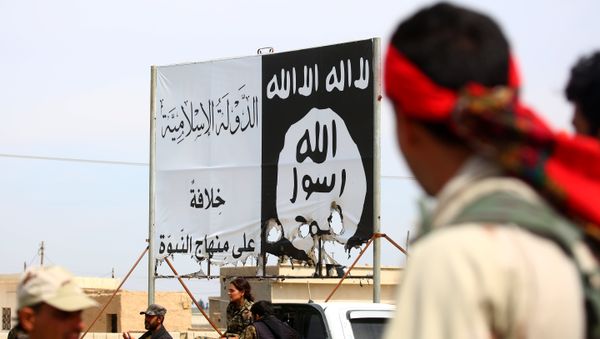 Members of the US-backed Syrian Democratic Forces (SDF), made up of an alliance of Arab and Kurdish fighters, stand under an Islamic State (IS) group banner in the recently recaptured town of Al-Karamah, 26 kms from the IS bastion of Raqa, as they advance to encircle the jihadists, on March 26, 2017 - Sputnik International