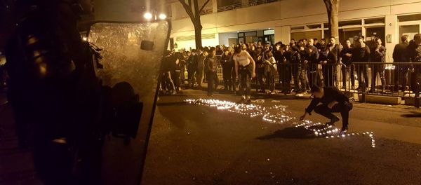 Youths use candles to write the word Violence in the road in front of a line of riot police outside the commisariat of the 19th Arrondissement (District) of Paris late on March 27, 2017, during clashes in the wake of the death of a Chinese national during a police intervention. Youths use candles to write the word Violence in the road in front of a line of riot police outside the commisariat of the 19th Arrondissement (District) of Paris late on March 27, 2017, during clashes in the wake of the death of a Chinese national during a police intervention. - Sputnik International