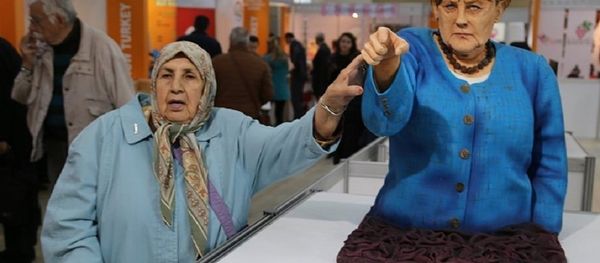 A visitor takes a picture next to the cake bust of German Chancellor Angela Merkel by Turkish confectioner Tuba Geçkil at the Festival of Chocolates, Sweets and Cakes in Istanbul. A visitor takes a picture next to the cake bust of German Chancellor Angela Merkel by Turkish confectioner Tuba Geçkil at the Festival of Chocolates, Sweets and Cakes in Istanbul. - Sputnik International