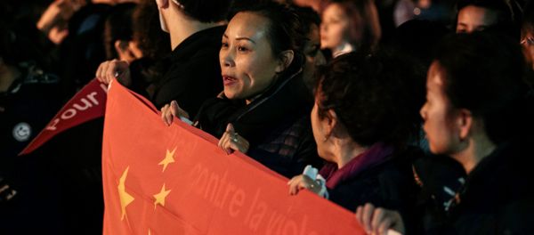 A woman holds a Chinese flag during a protest in front of the police headquarters in the 19th arrondissement of Paris on March 28, 2017, following the death of a Chinese national during a police intervention on March 26 A woman holds a Chinese flag during a protest in front of the police headquarters in the 19th arrondissement of Paris on March 28, 2017, following the death of a Chinese national during a police intervention on March 26 - Sputnik International