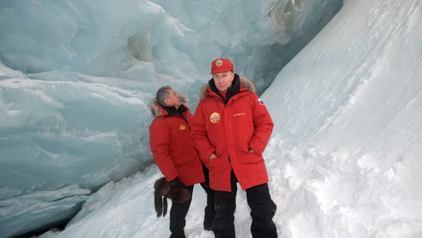 Russian President Vladimir Putin, foreground, and Defense Minister Sergei Shoigu, inspect a cavity in a glacier on the Arctic Franz Josef Land archipelago in Arctic Russia Russian President Vladimir Putin, foreground, and Defense Minister Sergei Shoigu, inspect a cavity in a glacier on the Arctic Franz Josef Land archipelago in Arctic Russia - Sputnik International