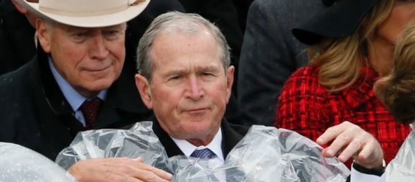George W. Bush struggles to put on a poncho during Donald Trump's inauguration. George W. Bush struggles to put on a poncho during Donald Trump's inauguration. - Sputnik International