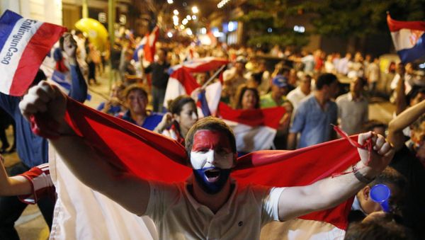 A youth holds a national Paraguay national flag as he marches with others in protest against the project to change the country's constitution, in Asuncion, Paraguay, Thursday, March 30, 2017. - Sputnik International