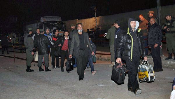 This photo released by the Syrian official news agency SANA, shows anti-Syrian government fighters, heading to a bus as they leave the last rebel-held neighborhood of al-Waer in Homs province, Syria, at dawn on Saturday, April. 1, 2017 - Sputnik International
