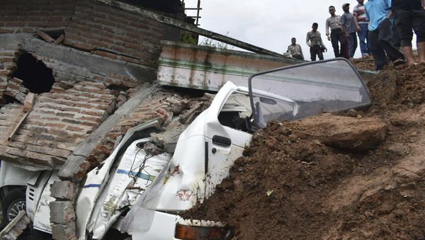 Rescuers inspect the damage in a neighborhood hit by a landslide in the village of Banaran, Ponorogo, East Java, Indonesia, Saturday, April 1, 2017. - Sputnik International