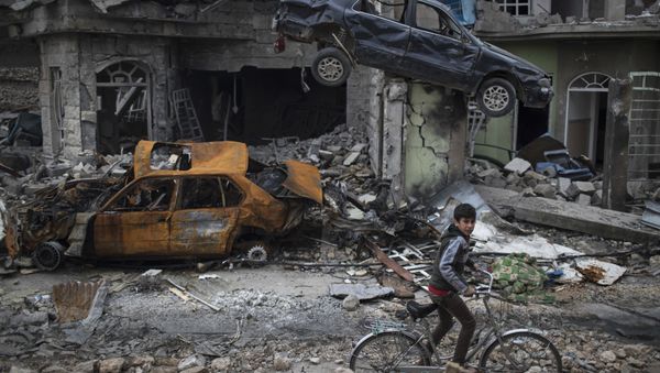 A boy rides his bike past destroyed cars and houses in a neighborhood recently liberated by Iraqi security forces, on the western side of Mosul, Iraq, Sunday, March 19, 2017 A boy rides his bike past destroyed cars and houses in a neighborhood recently liberated by Iraqi security forces, on the western side of Mosul, Iraq, Sunday, March 19, 2017 - Sputnik International