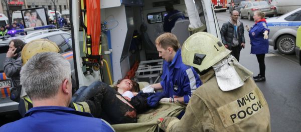 An injured person is helped by emergency services outside Sennaya Ploshchad metro station, following explosions in two train carriages at metro stations in St. Petersburg, Russia April 3, 2017 - Sputnik International