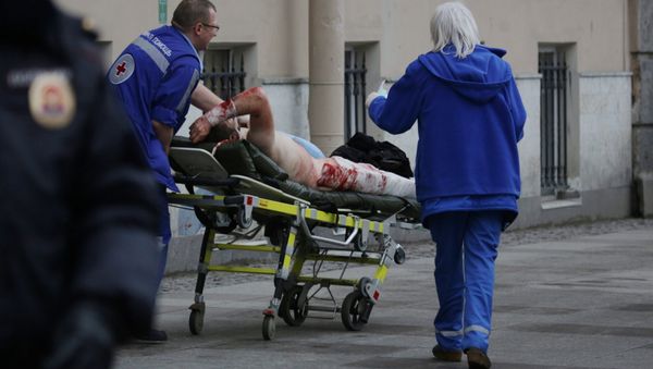 An injured person is helped by emergency services outside Sennaya Ploshchad metro station, following explosions in two train carriages at metro stations in St. Petersburg, Russia April 3, 2017 - Sputnik International