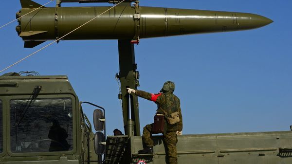 A Russian soldier watches a transporter-loader place an Iskander-M shorter-range missile onto a self-propelled launcher during an exercise involving missile and artillery units of the Eastern Military District's Fifth Russian Army in the Primorye Territory - Sputnik International