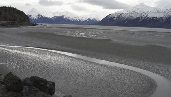 A ribbon of water cuts through the mud flats of Cook Inlet, just off the shore of Anchorage, Alaska. Natural gas is bubbling up from an underwater pipeline in Alaska's Cook Inlet. - Sputnik International