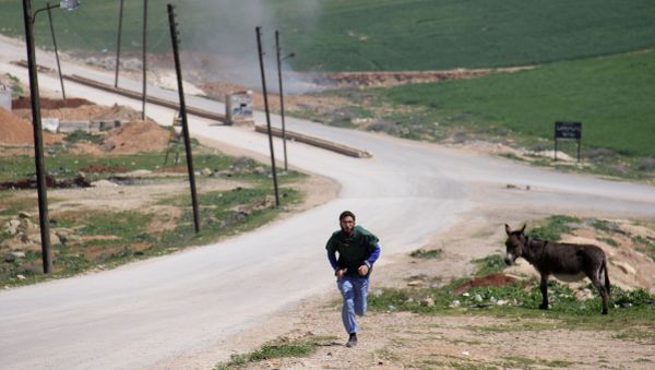 A Syrian medic runs for cover during the air strikes which hit a hospital in Khan Sheikhun, a rebel-held town in the northwestern Syrian Idlib province, on April 4, 2017 A Syrian medic runs for cover during the air strikes which hit a hospital in Khan Sheikhun, a rebel-held town in the northwestern Syrian Idlib province, on April 4, 2017 - Sputnik International