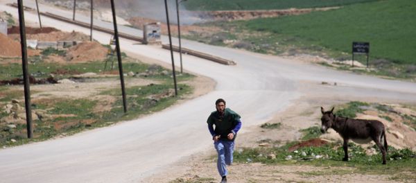A Syrian medic runs for cover during the air strikes which hit a hospital in Khan Sheikhun, a rebel-held town in the northwestern Syrian Idlib province, on April 4, 2017 A Syrian medic runs for cover during the air strikes which hit a hospital in Khan Sheikhun, a rebel-held town in the northwestern Syrian Idlib province, on April 4, 2017 - Sputnik International