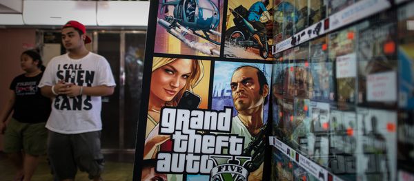 A man walks past a billboard of the Grand Theft Auto V video game in Hong Kong on September 17, 2013 - Sputnik International