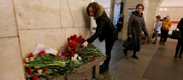 A woman lays flowers in memory of victims of a blast in St.Petersburg metro, at Tekhnologicheskiy institut metro station in St. Petersburg, Russia, April 4, 2017 - Sputnik International
