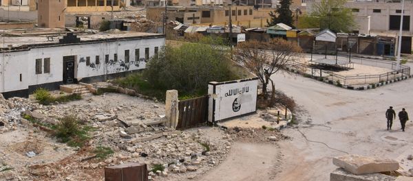 Syrian government forces walk near Islamic State (IS) group graffiti on a wall in Deir Hafer on the eastern outskirts of Aleppo on March 30, 2017, after they took control of the town from the jihadists. - Sputnik International
