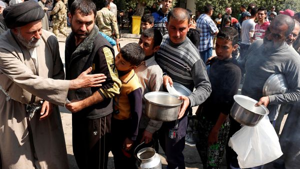 Civilians queue to collect food during food delivery in Western Mosul, Iraq March 30, 2017 - Sputnik International