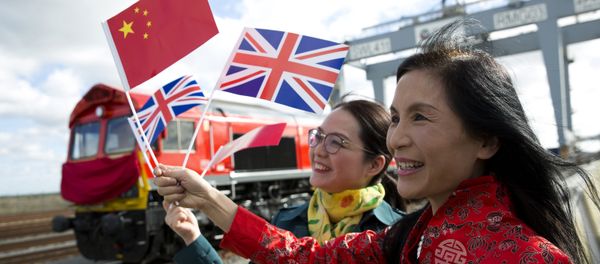 People wave a Chinese and a Union flags as they pose for photographs during a photcall to witness the departure of a freight train transporting containers laden with goods from the UK, from DP World London Gateway's rail freight depot in Corringham, east of London, on April 10, 2017, enroute to Yiwu in the eastern Chinese province of Zhejiang. - Sputnik International