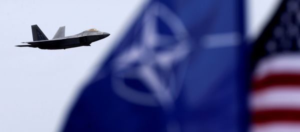 NATO and US flags flutter as U.S. Air Force F-22 Raptor fighter flies over the military air base in Siauliai, Lithuania, April 27, 2016. NATO and US flags flutter as U.S. Air Force F-22 Raptor fighter flies over the military air base in Siauliai, Lithuania, April 27, 2016. - Sputnik International
